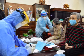 Nhân viên y tế triển khai tiêm chủng cho người dân tại nhà. (Ảnh: THÀNH ĐẠT)