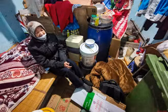 Bà Thìn dùng bìa các-tông làm chiếu rải dưới đất trong những ngày giá rét lịch sử. (ẢNH: THÀNH ĐẠT)