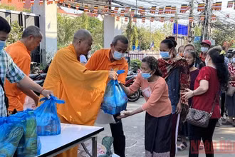 Thượng tọa Thích Minh Quang (thứ 3 từ trái qua) trao hỗ trợ kiều bào nghèo ở Thủ đô Vientiane trong lễ Thượng nguyên 2022. (ẢNH: XUÂN SƠN)