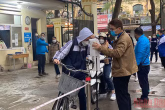 Kiểm tra thân nhiệt cho học sinh trước khi vào lớp tại Trường THPT Việt Đức (quận Hoàn Kiếm, Hà Nội).