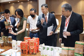 Các đại biểu tham quan gian hàng trưng bày sản phẩm của doanh nghiệp trong nước tại hội nghị.