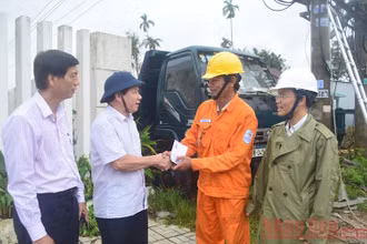 Chủ tịch UBND tỉnh Quảng Ngãi Đặng Văn Minh (thứ hai từ trái sang) động viên công nhân ngành điện vượt qua khó khăn trong việc khôi phục lưới điện bị hư hỏng. (Ảnh: HIỂN CỪ)