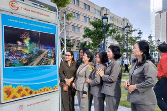 Các đại biểu tham quan các hình ảnh về thành tựu của TP Hồ Chí Minh tại triển lãm.