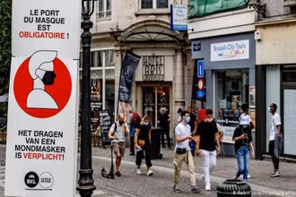 Người dân đeo khẩu trang khi di chuyển trên đường phố Brussels, Bỉ. (Ảnh: DW)