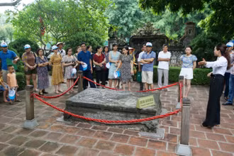 Khách du lịch tham quan “Long sàng” trước nghi môn ngoại đền vua Đinh.