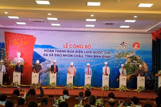 Các đại biểu thực hiện nghi thức đóng điện dự án đưa điện lưới Quốc gia ra xã đảo Nhơn Châu, thành phố Quy Nhơn.