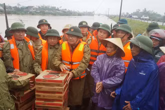 Phó Thủ tướng Trịnh Đình Dũng động viên và trao quà cho người dân vùng lũ.