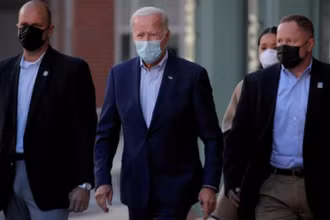 Ứng cử viên Tổng thống Mỹ Joe Biden (đứng giữa) có kết quả âm tính với virus SARS-CoV-2 ở lần xét nghiệm thứ hai. Ảnh: Reuters