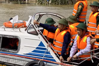Bộ trưởng Nông nghiệp và Phát triển nông thôn, Phó Ban chỉ đạo T.Ư về Phòng chống thiên tai Nguyễn Xuân Cường đi cano kiểm tra vùng lũ Lệ Thủy, Quảng Bình ngày 22-10. Ảnh: HƯƠNG GIANG.