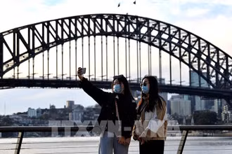 Du khách chụp ảnh tại khu vực Cầu Cảng Sydney, Australia. (Ảnh: AFP/TTXVN)