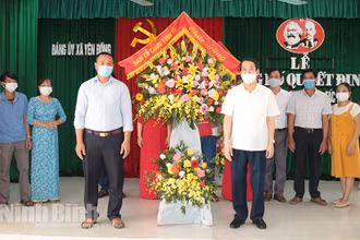 Đồng chí Mai Văn Tuất, Trưởng Ban Tổ chức Tỉnh ủy tặng hoa chúc mừng thành lập Chi bộ HTX chăn nuôi thủy sản Sông Đằng tháng 6/2021 (xã Yên Đồng, huyện Yên Mô). Ảnh: Thái Học