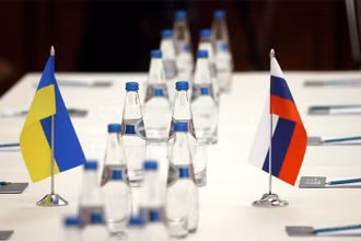 Quốc kỳ Nga và Ukraine trên bàn đàm phán trước khi hai phái đoàn bắt đầu đàm phán tại vùng Gomel, gần biên giới Belarus-Ukraine, ngày 28/2. (Ảnh: Reuters)