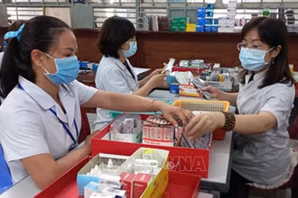 Nhân viên y tế chuẩn bị thuốc để cấp cho bệnh nhân điều trị ngoại trú có tham gia bảo hiểm y tế. (Ảnh minh họa: TTXVN)