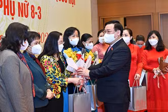 Chủ tịch Quốc hội Vương Đình Huệ tặng hoa, tặng quà chúc mừng các nữ đại biểu. (Ảnh: DUY LINH)