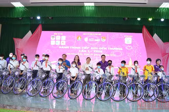 Các đồng chí Phan Văn Thắng, Huỳnh Minh Thức, cùng thành viên Câu lạc bộ ACE Charity trao tặng xe đạp cho học sinh. (Ảnh: HỮU NGHĨA)