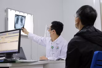 Bác sĩ Đinh Thế Tiến khám cho bệnh nhân hậu Covid-19.