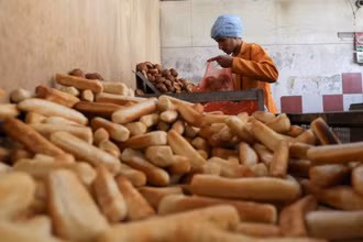 Thợ làm bánh gói những ổ bánh mì vào túi nilon tại 1 tiệm bánh ở Sanaa, Yemen, ngày 1/3/2022. (Ảnh: REUTERS)
