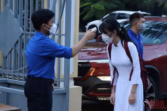 Đo thân nhiệt cho học sinh trước khi vào lớp học trực tiếp tại Đồng Nai. 