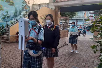Học sinh Trường trung học cơ sở Lý Phong, quận 5, Thành phố Hồ Chí Minh kiểm tra thân nhiệt, sát khuẩn tay trước khi vào học (thời điểm dịch Covid-19 đang diễn ra phức tạp).