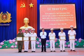 Chủ tịch Ủy ban nhân dân tỉnh Cà Mau (áo trắng) tặng Bằng khen cho các cá nhân phá nhanh các vụ trọng án. 