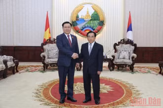 Thủ tướng Lào Phankham Viphavanh (phải) đón Chủ tịch Quốc hội Vương Đình Huệ, sáng 17/5. (Ảnh: Xuân Sơn)