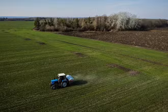 Máy kéo rải phân bón trên cánh đồng lúa mì gần làng Yakovlivka, gần TP Kharkiv, ngày 5/4/2022. (Ảnh: Reuters)