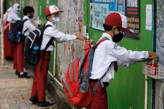 Học sinh tiểu học sát khuẩn tay sau khi tan học ở Jakarta, Indonesia, ngày 30/8/2021. (Ảnh minh họa: Reuters)