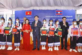 Chủ tịch Quốc hội Vương Đình Huệ tặng quà cho các cháu học sinh giỏi tại Trường phổ thông Dân tộc nội trú tỉnh Champasak (Lào), chiều 17/5. (Ảnh: TTXVN)