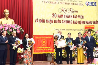 Đồng chí Nguyễn Văn Nên, Ủy viên Bộ Chính trị, Bí thư Thành ủy Thành phố Hồ Chí Minh (bên trái) trao Huân chương Lao động hạng Nhì cho tập thể Viện nghiên cứu phát triển Phương Đông.