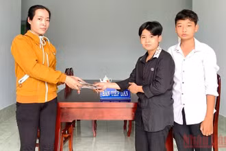 2 em học sinh trao lại chiếc ví cho người đánh rơi.