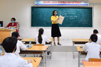 Cán bộ coi thi cùng thí sinh xác nhận túi đề thi còn niêm phong tại điểm thi Trường Trung học phổ thông Nguyễn Gia Thiều, Hà Nội tại Kỳ thi tốt nghiệp Trung học phổ thông năm 2021. (Ảnh: Mỹ Hà)