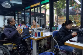 Anh Pham Việt Hoài trao đổi với nhân viên xưởng may về sản phẩm đang hoàn thiện.