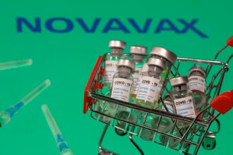 Hình minh họa lọ vaccine Covid-19 đặt cạnh logo Novavax được chụp vào ngày 29-11. Ảnh: Reuters.