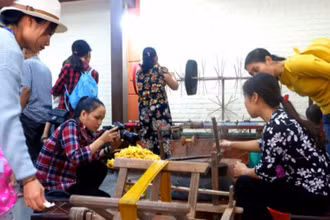 Khách hàng tham quan quy trình sản xuất lụa tơ tằm tại làng Vạn Phúc (quận Hà Đông).