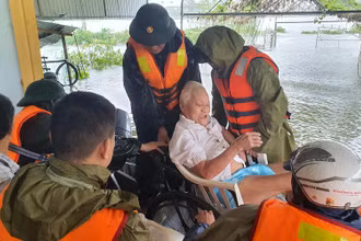 Công an huyện Thạch Hà giúp dân sơ tán trong mưa lũ. (Ảnh: NGÔ TUẤN)