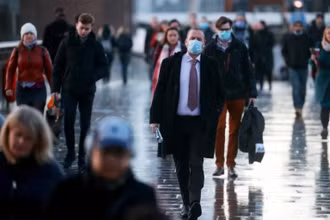 Người dân đi bộ qua cầu London ngày 15-12 khi Covid-19 tiếp tục lây lan ở Anh. Ảnh: Reuters.