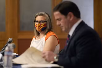 Thư ký bang Arizona State Katie Hobbs (bên trái) chứng kiến Thống đốc bang Doug Ducey ký văn bản xác nhận kết quả bầu cử của bang này, ngày 30-11. (Ảnh: AP)