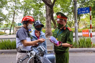Lực lượng chức năng nhắc nhở người dân thực hiện nghiêm công tác phòng, chống dịch. (Ảnh: Minh Sơn/Vietnam+)