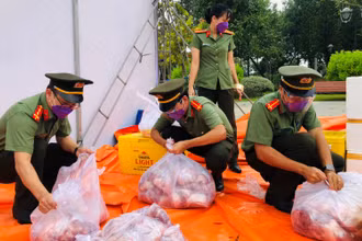 Chiến sĩ Công an tỉnh Đồng Nai chia thịt heo ra từng gói nhỏ trước khi đưa đi trao tặng người dân.
