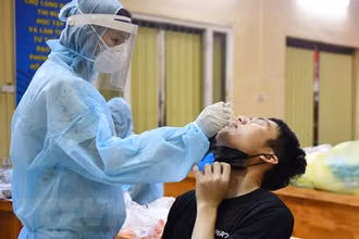 Trung tâm Y tế quận Ba Đình lấy mẫu xét nghiệm cho các tiểu thương và nhân viên Ban Quản lý chợ Long Biên. (Ảnh: TTXVN)