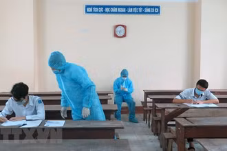 Hai thí sinh trong khu vực phong toả ở Phú Yên được bố trí phòng thi riêng, cán bộ coi thi mặc đồ bảo hộ. Ảnh: XUÂN TRIỆU/TTXVN