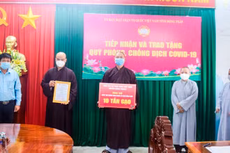 Đại diện Ban Trị sự Phật giáo Việt Nam huyện Châu Thành trao tặng bảng tượng trưng 10 tấn gạo.