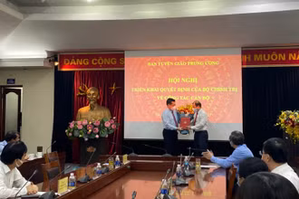 Đồng chí Nguyễn Trọng Nghĩa trao quyết định và tặng hoa, chúc mừng đồng chí Lê Hải Bình.