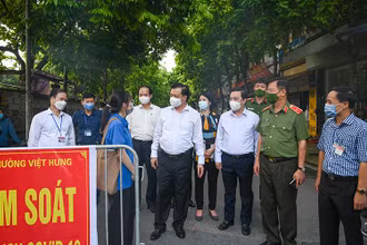 Bí thư Thành uỷ Đinh Tiến Dũng thăm hỏi, động viên lực lượng làm nhiệm vụ tại chốt kiểm soát dịch Covid-19 làng Lệ Mật, phường Việt Hưng (Long Biên). Ảnh: Duy Linh.