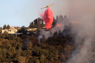 Máy bay rải chất dập lửa gần làng Beit Meir, ngoại ô Jerusalem, ngày 16/8. (Ảnh: Reuters)