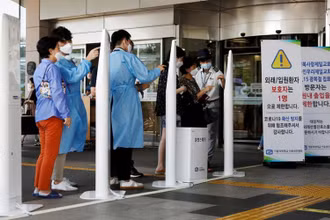 Khách vào một bệnh viện tại Seoul phải điền mẫu khai báo y tế. (Ảnh: Reuters)