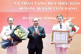 Chủ tịch nước Nguyễn Xuân Phúc trao tặng Huy hiệu 40 năm tuổi Đảng cho Đại tướng Tô Lâm, Ủy viên Bộ Chính trị, Bộ trưởng Công an, và Thượng tướng Lê Quý Vương, nguyên Ủy viên Trung ương Đảng, nguyên Thứ trưởng Công an. (Ảnh: TTXVN)