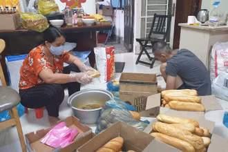 Một nhóm thiện nguyện chuẩn bị các suất ăn cho lực lượng tuyến đầu tại bệnh viện dã chiến.
