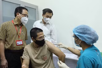 GS, TS Tạ Thành Văn và GS, TS Trần Văn Thuấn chứng kiến mũi tiêm thử nghiệm cho tình nguyện viên đầu tiên. (Ảnh: NGUYỄN QUYẾT)