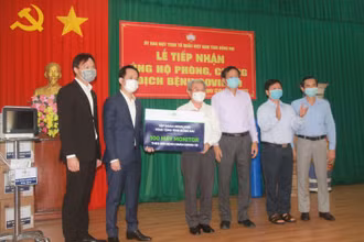 Đại diện Tập đoàn Novaland trao bảng tượng trưng hỗ trợ 100 máy monitor cho tỉnh Đồng Nai.